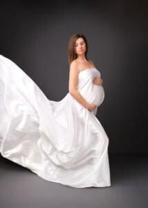 Serene maternity elegance in a flowing white dress, captured in a timeless Nottingham photography session.