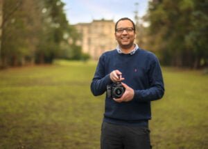 Photographer smiling during a business photography shoot at a park location.