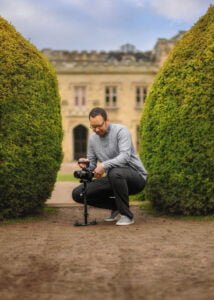 Photographer adjusting equipment in a garden for a professional business photography session.