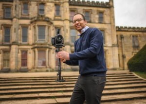Photographer on castle steps preparing for a corporate business photography session.