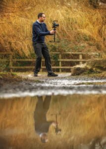Photographer creating dynamic business photography by a riverside location.