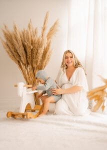 Heartwarming maternity portrait featuring a mom-to-be with her child and a wooden toy horse in a Nottingham studio.
