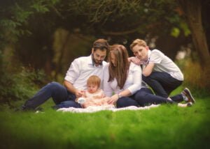 Family sitting together on a blanket outdoors during a 1st Birthday Photoshoot in Nottingham.