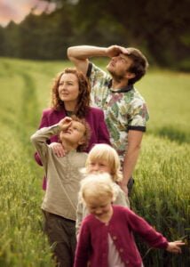 Family looking into the distance in a wheat field during an outdoor family photoshoot in Nottingham.