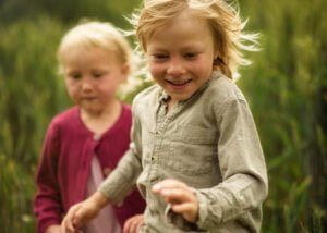 Close-up of two smiling children enjoying an outdoor family photoshoot in Nottingham.
