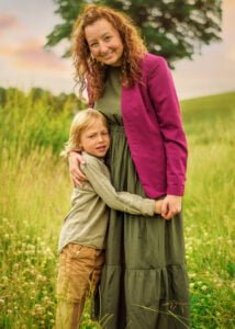 Mother hugging her son in a meadow during an outdoor family photoshoot in Nottingham.
