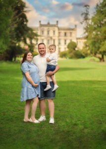 A family posing in front of a historic Nottingham building during a family photoshoot in an outdoor park.