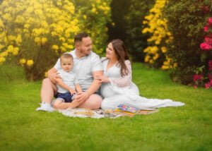 A family sitting on a picnic blanket surrounded by vibrant flowers during a family photoshoot in Nottingham.