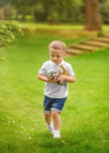 A young boy walking with toy animals during an outdoor family photoshoot in Nottingham.