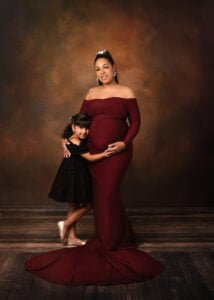 Mother and daughter posing elegantly during a maternity photography session.
