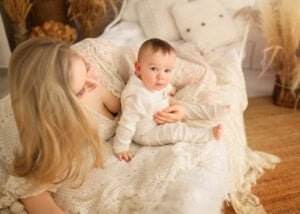 Mother reclining with her baby in a cozy, boho-inspired baby photography session.