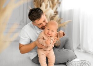 Father sitting with his baby in a studio, photographed by a Nottingham professional family photographer.
