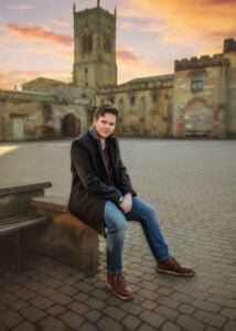 Cinematic men’s photoshoot at sunset, featuring a stylish man in a black coat in a historic Nottingham location.