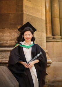 Female graduate holding diploma in cap and gown at Nottingham University