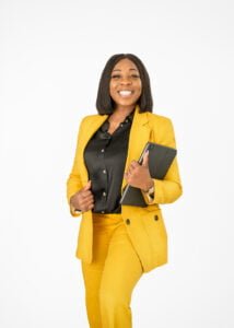 Businesswoman in a yellow suit smiling confidently during a professional business photography session.