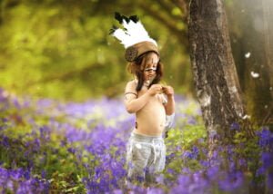 boy wearing indian headpiece in bluebells field, Nottingham children photographer