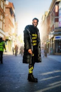 Fashion-forward men’s photoshoot featuring a man in bold streetwear posing in a Nottingham city setting.