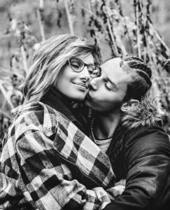 Tender embrace in monochrome: Couple sharing a gentle kiss amidst autumn reeds in Nottinghamshire.