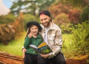 Business photography of a father and daughter enjoying a book outdoors, creating a joyful and personal brand story.
