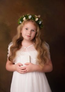 Girl holding Bible and wearing flower crown in studio First Holy Communion Photography