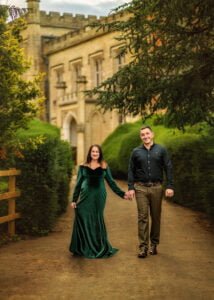 Couple walking hand-in-hand during maternity photography session at historic location in Nottingham