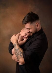 Tender moment between father and baby captured by Eastwood's affordable family photography service.