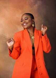 A confident woman in a vibrant orange blazer, showcasing Affordable Family Photography in Eastwood, Nottingham.