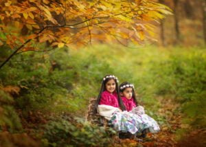 sisters sitting on a birch bench in Sherwood Pines forest during Family Photo Shoot in Nottingham with professional photographer who cover Nottinghamshire and Derbyshire