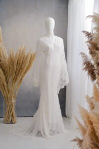 Elegant long white lace gown with bell sleeves for photoshoots