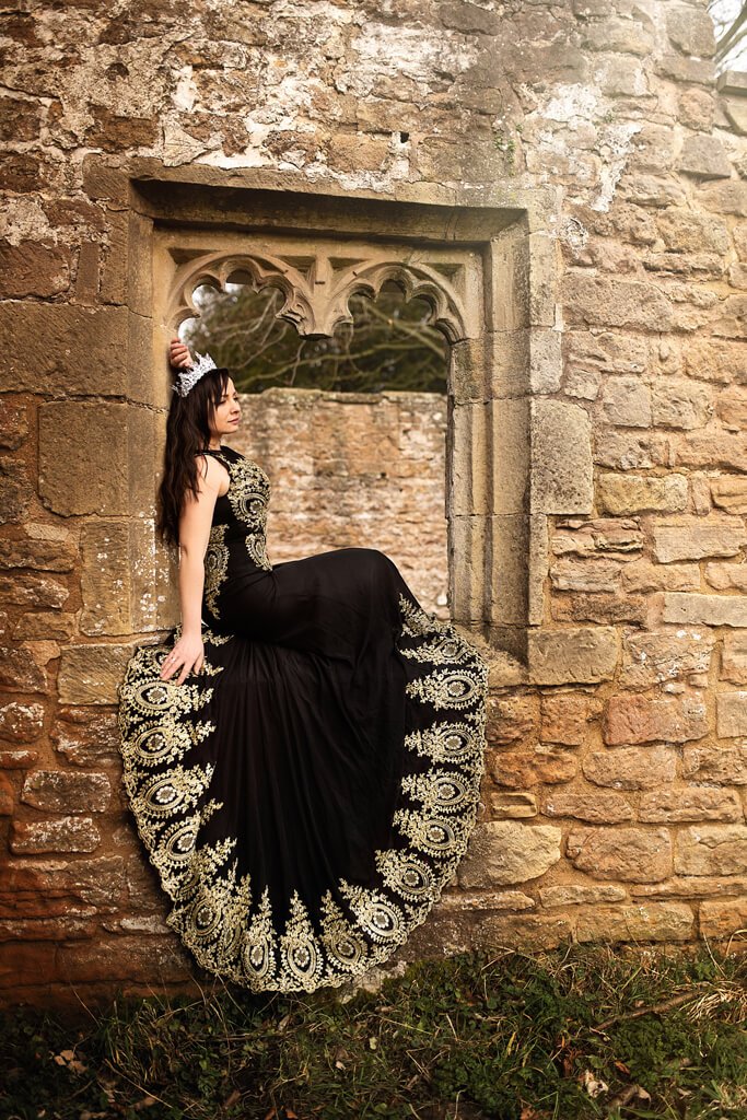 Elegant Woman in Black Gown at Castle Ruins