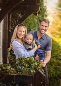 Parents holding their baby and smiling during a family photography session in Nottingham