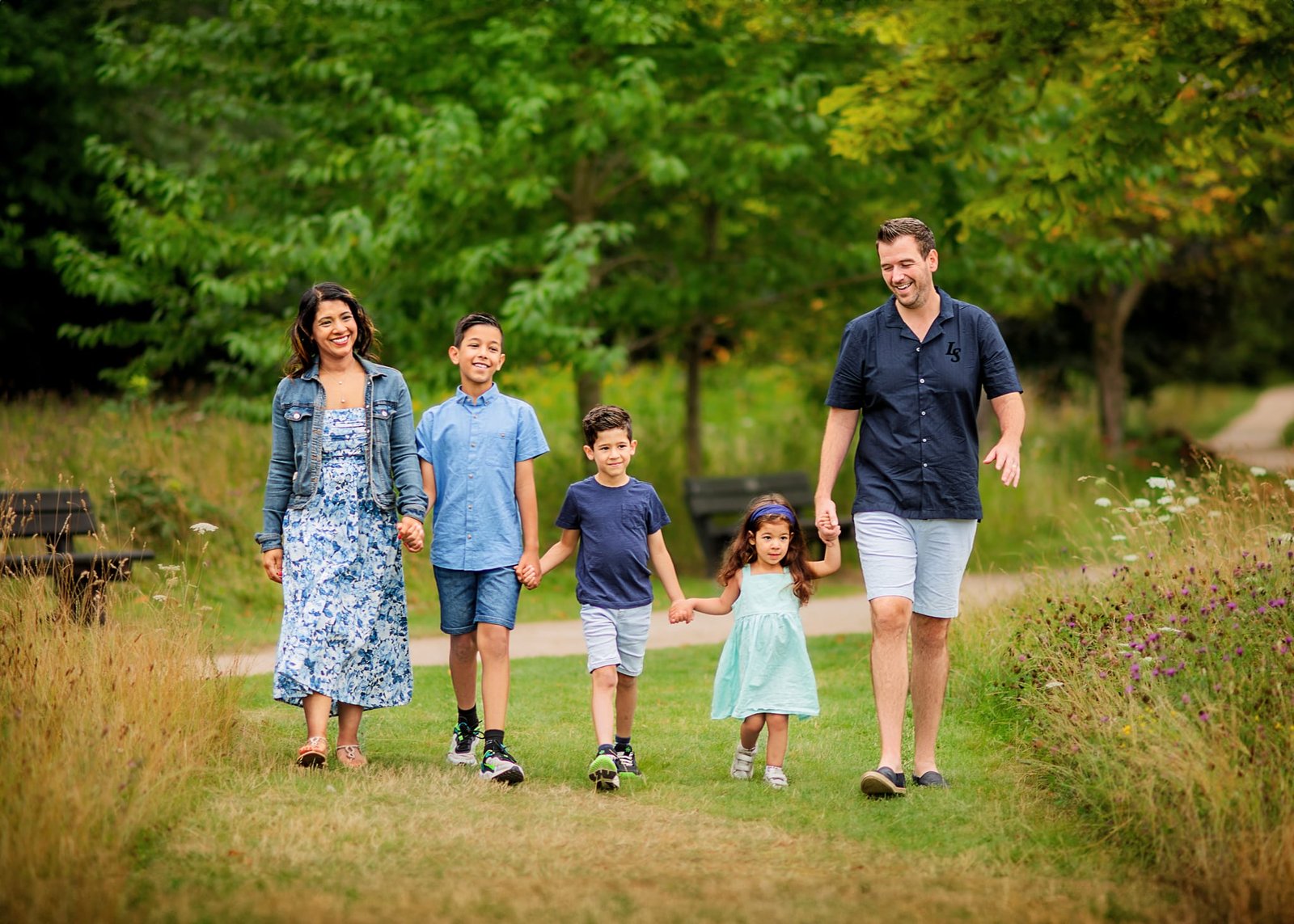 Family walking hand in hand during their outdoor family photography session in Nottingham