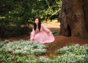 Professional woman portrait in pink dress amid white flowers, Nottingham.