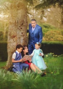 Nottingham Family Photographer - Family of 4 having fun during a natural photoshoot under a blooming daffodil tree at Elvaston Castle in Derby in spring.