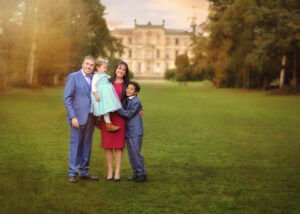 Happy family posing in front of Elvaston Castle during a professional outdoor photoshoot in spring by Nottingham Family Photographer.