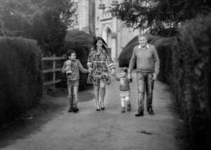 Nottingham Family Photographer - Happy family taking a walk with their kids, with the majestic Elvaston Castle in the background, captured during a spring outdoor photoshoot.