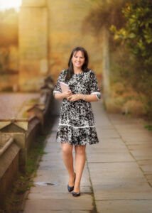 Portrait of a mum holding a diary and walking at Elvaston Castle Park in Derby during a professional family outdoor photoshoot in spring. She is a blog writer and admires the surrounding nature. This image is a part of the blog post: Tips for Making the Most of Your Family Photography Session.