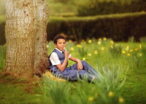 Fine art portrait of a boy celebrating his first holy communion among blooming daffodils during a spring outdoor photoshoot at Elvaston Castle Park in Derby by Nottingham Family Photographer