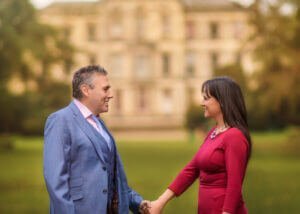Parents holding hands at Elvaston Castle Park during a family photoshoot among blooming daffodils in spring. Captured by Nottingham Family Photographer.