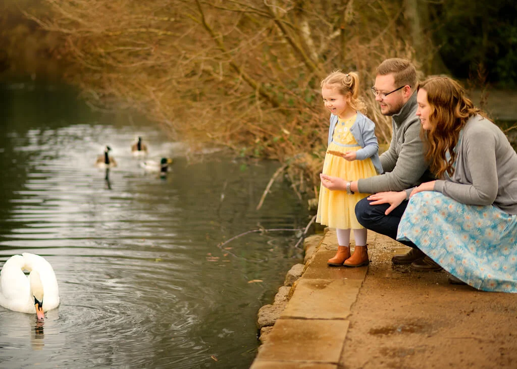 A joyful family laughing and posing together during a professional photo shoot with Marta Szulc, a skilled Nottingham family photographer
