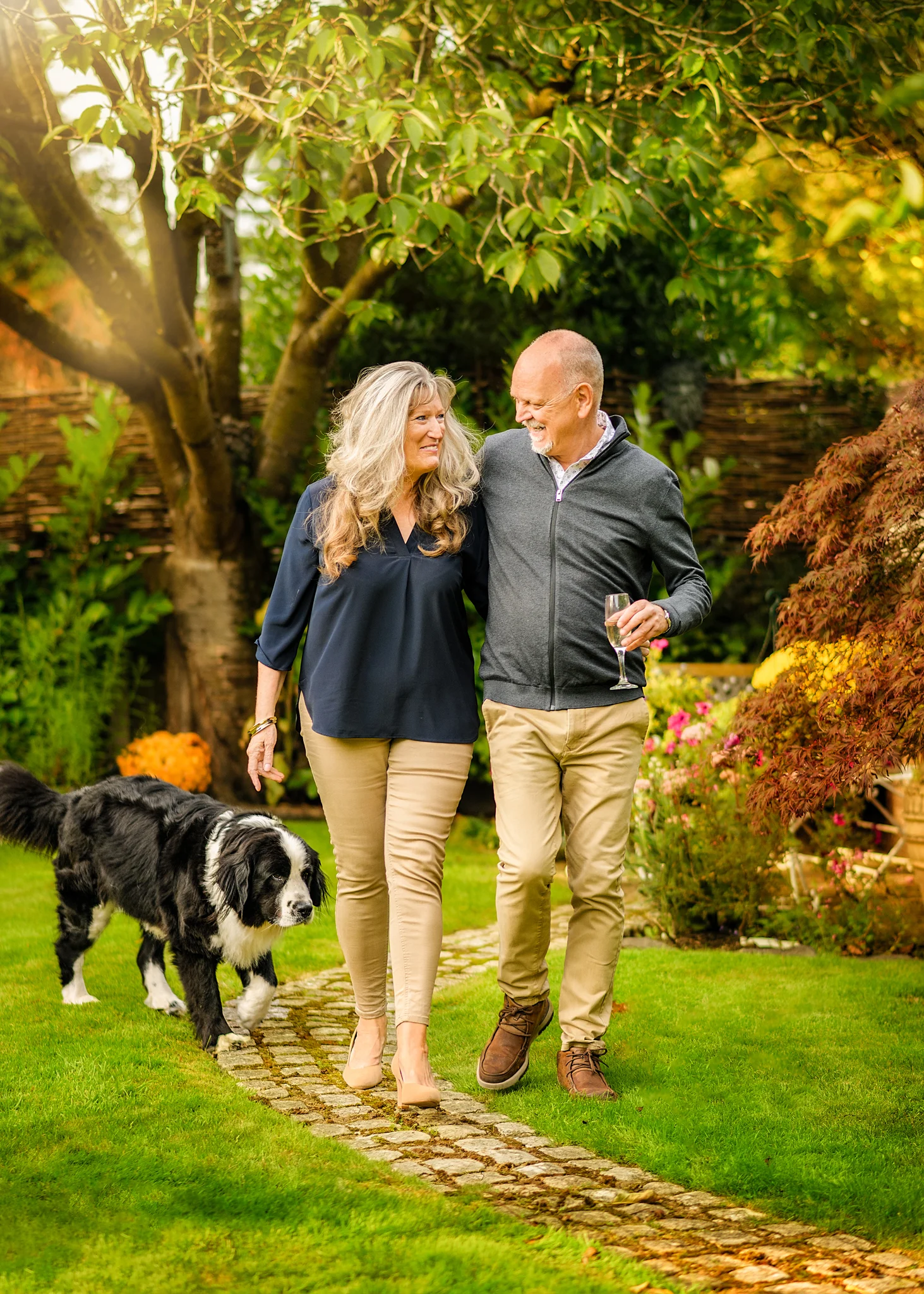 Senior couple walking with their dog in a blooming garden, enjoying their golden years together in Nottingham.