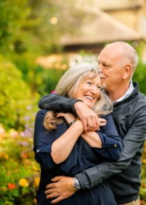 Couple in a warm embrace, celebrating an anniversary in the vibrant gardens of Nottingham