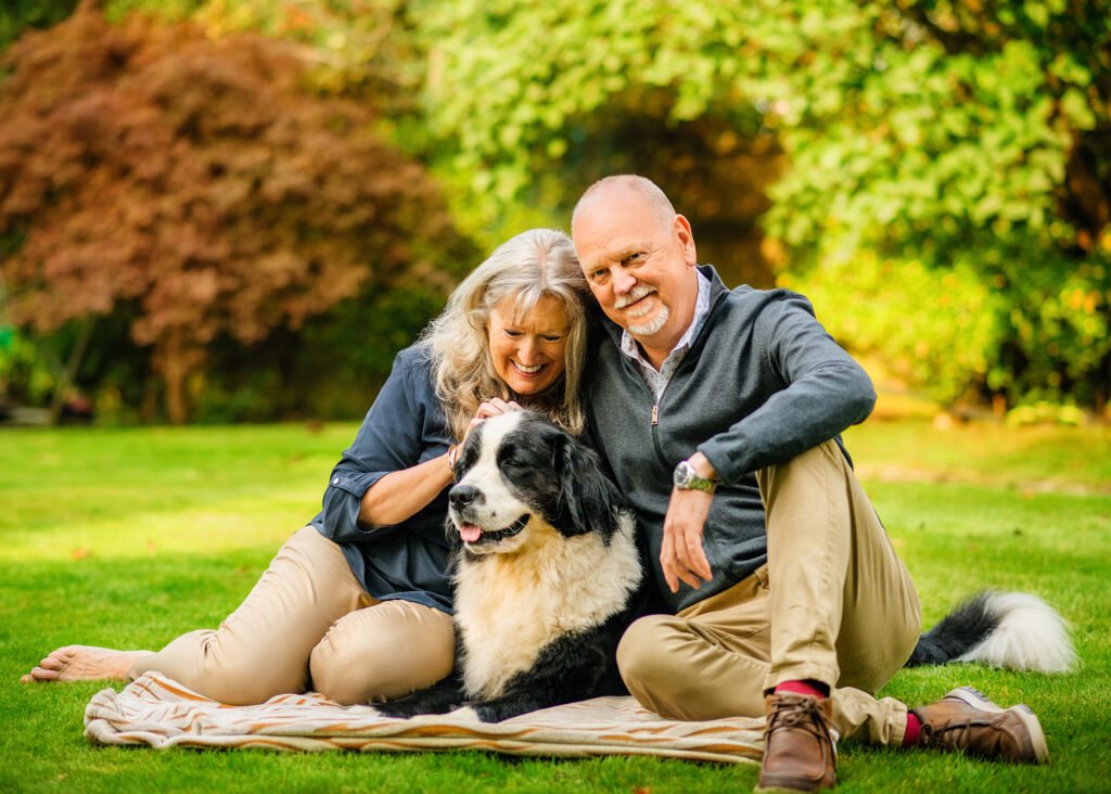 Couple with their dog enjoying a relaxing moment on a picnic blanket in Nottingham's verdant garden.
