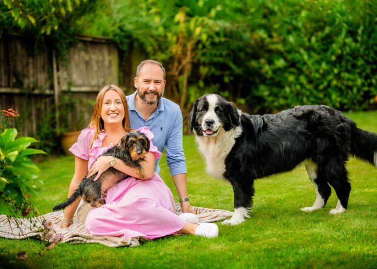 Joyful couple with their dogs enjoying a garden photoshoot in Nottingham, sharing a moment of happiness.