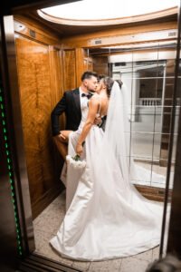 Bride and groom share a passionate kiss in an elegant elevator, symbolizing modern wedding photography in Nottingham.