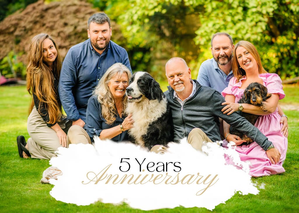 Joyful family with pets celebrating a 5-Year Anniversary in a lush green garden.