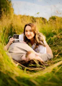 Pregnant woman holding ultrasound photo during maternity shoot in Nottingham.