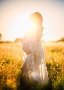 Pregnant woman bathed in sunset light during a maternity session in Nottingham.