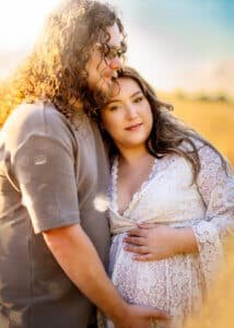 Joyful couple embracing during their maternity photography session in Nottingham.