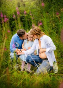 Expecting parents kissing their daughter during a maternity photo shoot in Nottingham